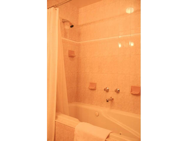 Furnished bathroom with beige tiles and a bathtub. - 3199 Pt. Grey Road, Vancouver West Side