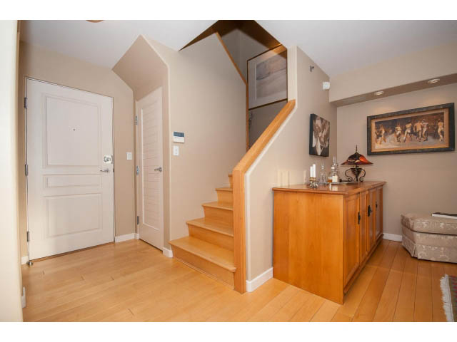 Bright entryway with wooden floors, staircase leading to upper level, and framed artwork on wall. - 1404 - 819 Hamilton Street, Vancouver Downtown