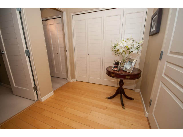 Foyer with hardwood floors, white closet doors, and a small table with flowers. - 1404 - 819 Hamilton Street, Vancouver Downtown