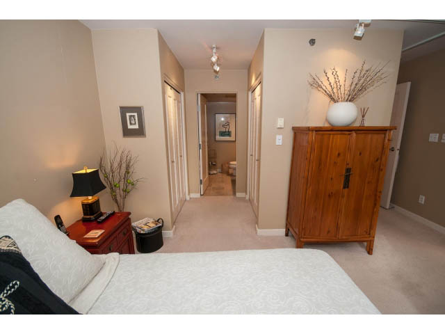 Spacious bedroom with wooden furniture, neutral decor, and a cozy ambiance. - 1404 - 819 Hamilton Street, Vancouver Downtown