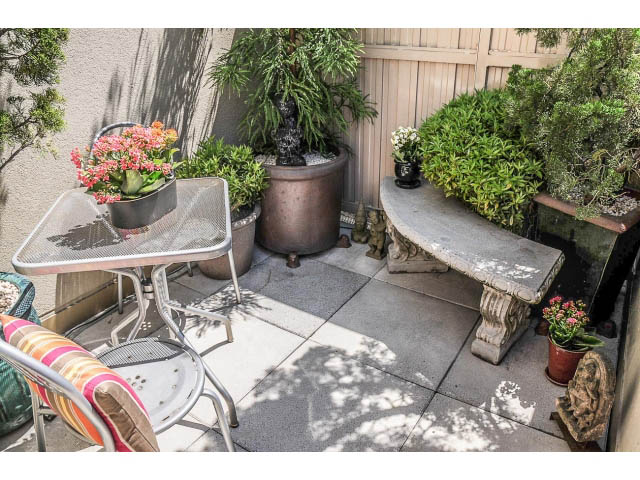 Bright patio with outdoor furniture, plants, and a stone table. - 1404 - 819 Hamilton Street, Vancouver Downtown