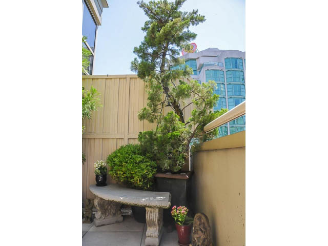 Furnished patio with stone bench, potted plants, and city view. - 1404 - 819 Hamilton Street, Vancouver Downtown