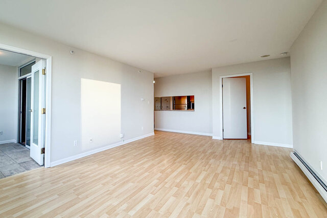 The living room with glass French doors into the den and the kitchen pass-through beyond - 15B-199 Drake Street, Vancouver Downtown