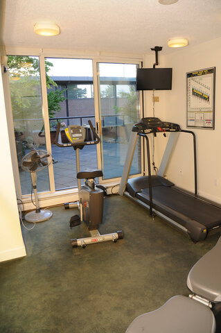 A bike and treadmill by glass doors onto the patio - 15B-199 Drake Street, Vancouver Downtown