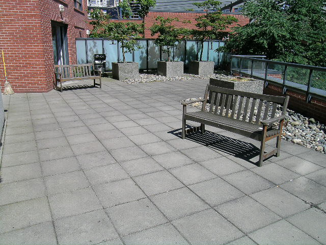 The building's shared patio with benches, a BBQ and planters - 15B-199 Drake Street, Vancouver Downtown