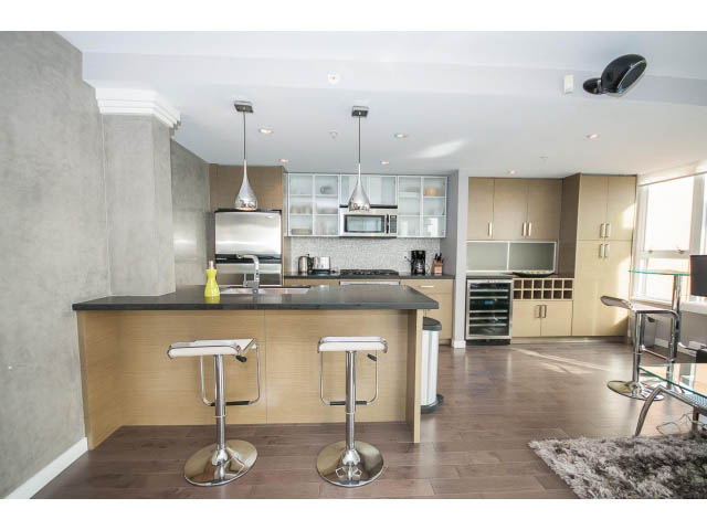Bright kitchen with modern appliances, wooden cabinets, and hardwood floors. - 2203 - 33 Smithe Mews, Vancouver Downtown