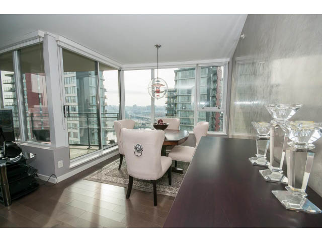 Furnished dining area with city view, modern decor, hardwood floors, and glass vases on countertop. - 2203 - 33 Smithe Mews, Vancouver Downtown