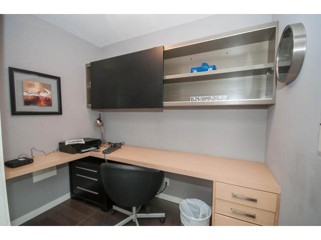 Furnished den with light wood countertops, black chair, and wall-mounted shelves. - 2203 - 33 Smithe Mews, Vancouver Downtown