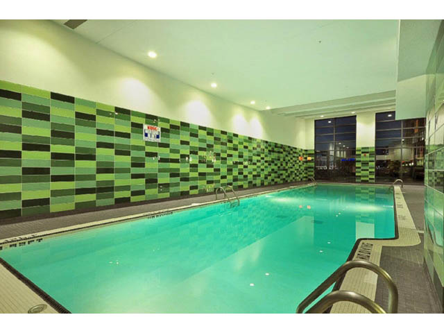 Furnished living room with modern green tile accent wall and large windows. - 2203 - 33 Smithe Mews, Vancouver Downtown
