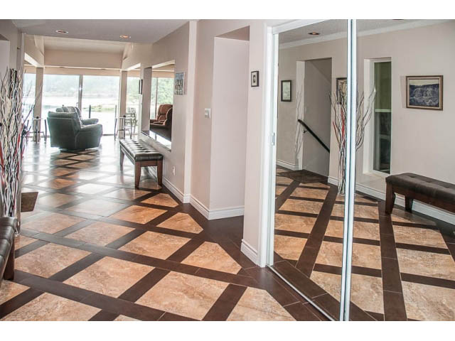 Furnished living room with patterned tile flooring, large windows, and a cozy seating area. - 4541 Strathcona Road, North Vancouver