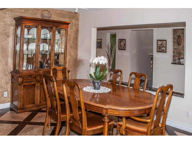 Dining room with wooden table, chairs, and china cabinet. - 4541 Strathcona Road, North Vancouver