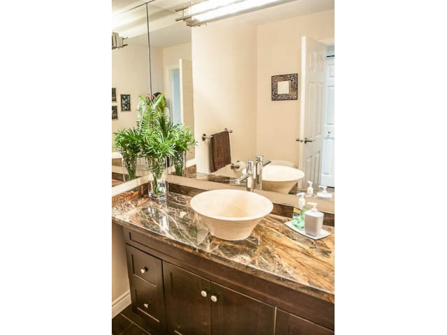 Furnished bathroom with marble countertop and large mirror. - 4541 Strathcona Road, North Vancouver