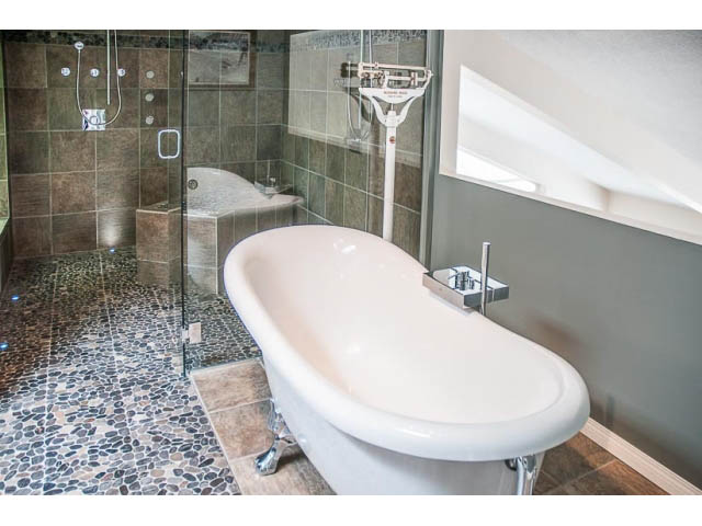 Bathroom with modern fixtures, pebble tile floor, and large shower. - 4541 Strathcona Road, North Vancouver