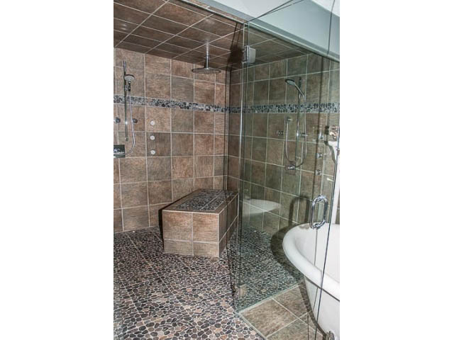 Spacious bathroom with tiled shower and mosaic floor. - 4541 Strathcona Road, North Vancouver