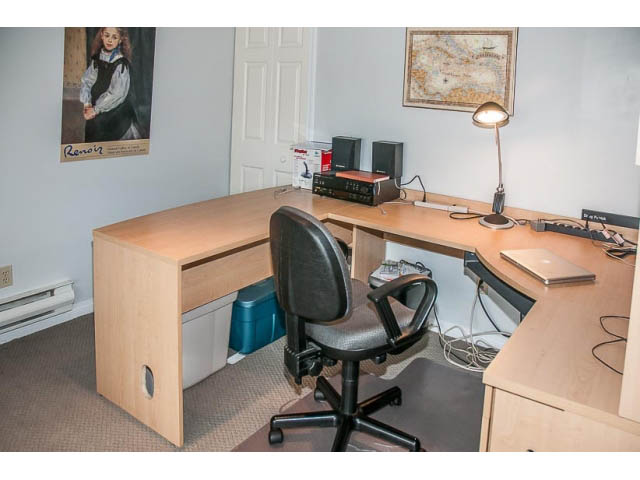 Furnished office with curved desk, chair, and map on wall. - 4541 Strathcona Road, North Vancouver