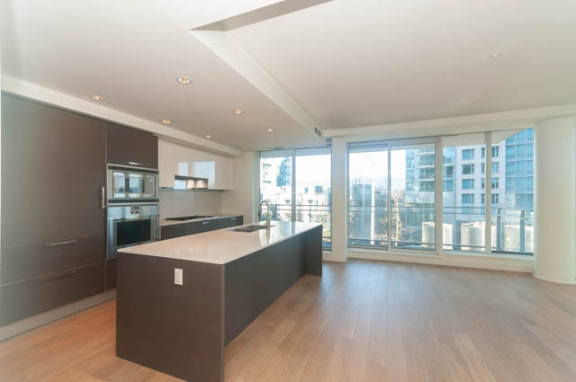 Bright kitchen with dark cabinetry, hardwood floors, and a city view. - 202 - 1409 W Pender St, Vancouver Downtown