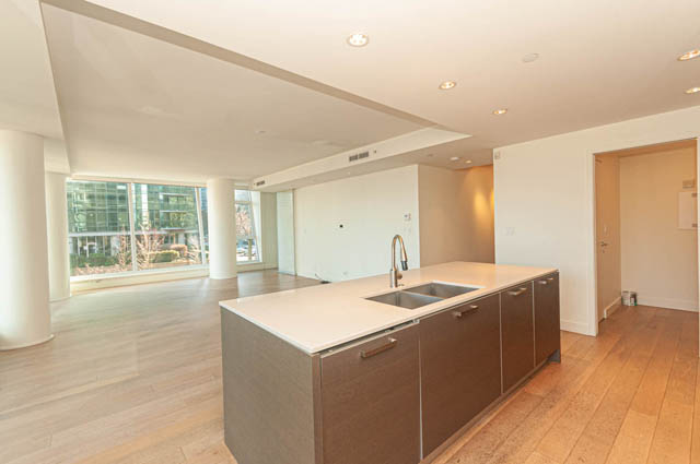 Bright kitchen with modern countertops and hardwood floors, featuring a city view. - 202 - 1409 W Pender St, Vancouver Downtown