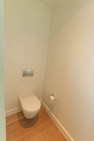 Bright bathroom with white toilet and wooden flooring. - 202 - 1409 W Pender St, Vancouver Downtown