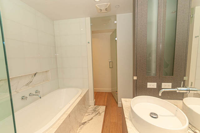 Modern bathroom with marble countertops and hardwood floors. - 202 - 1409 W Pender St, Vancouver Downtown