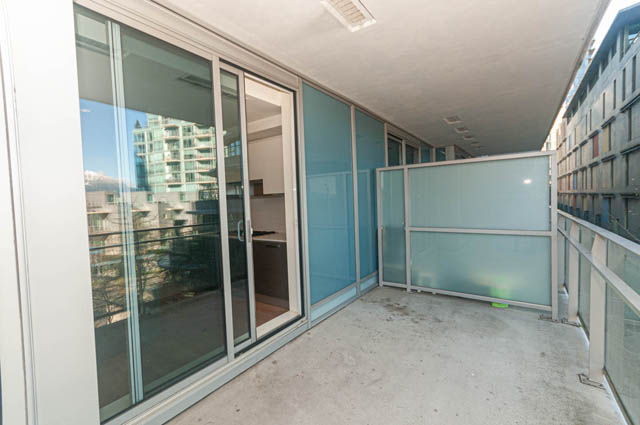 Bright balcony with glass railings, city view, and modern furnishings. - 202 - 1409 W Pender St, Vancouver Downtown
