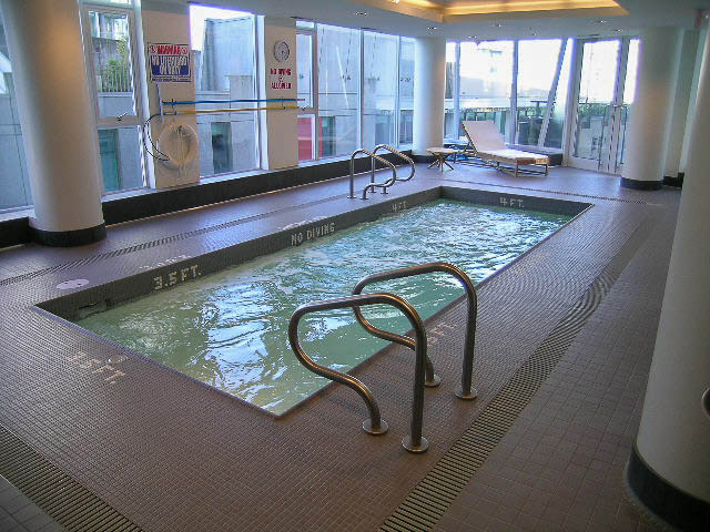 Spacious indoor pool with city view and lounge chairs. - 202 - 1409 W Pender St, Vancouver Downtown