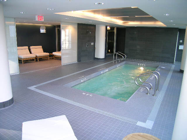 Spacious indoor pool area with tiled flooring and lounge seating. - 202 - 1409 W Pender St, Vancouver Downtown
