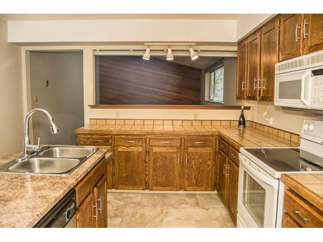 Bright kitchen with granite countertops and wooden cabinets, featuring a city view. - 2039 McLallen Court, North Vancouver
