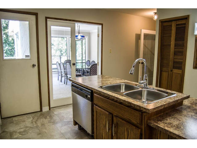 Bright kitchen with granite countertops and hardwood floors, leading to a dining area with a view. - 2039 McLallen Court, North Vancouver