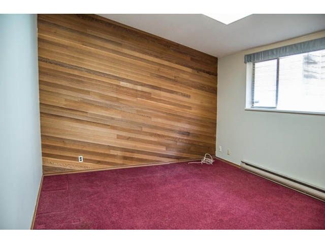 Bright living room with hardwood walls and maroon carpet. - 2039 McLallen Court, North Vancouver