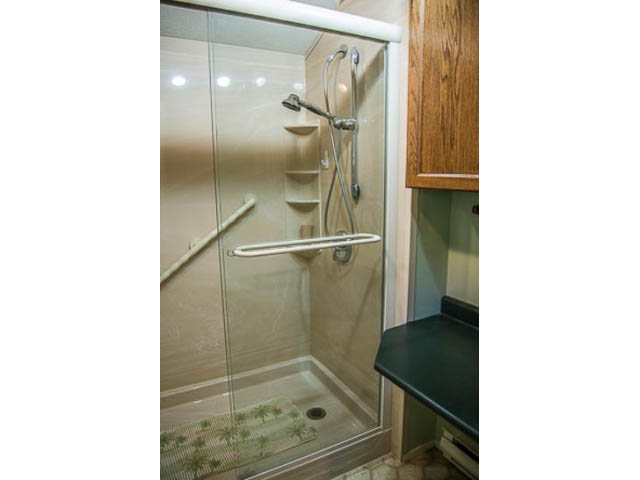 Bright bathroom with glass shower, wooden cabinets, and green countertop. - 2039 McLallen Court, North Vancouver