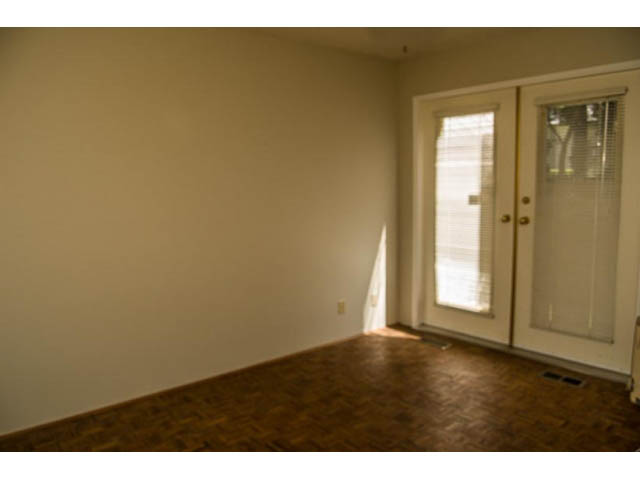 Empty living room with hardwood floors and sliding glass doors leading outside. - 2039 McLallen Court, North Vancouver
