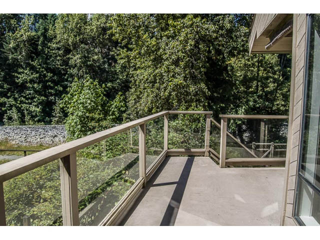 Balcony with wooden railings and view of lush greenery. - 2039 McLallen Court, North Vancouver