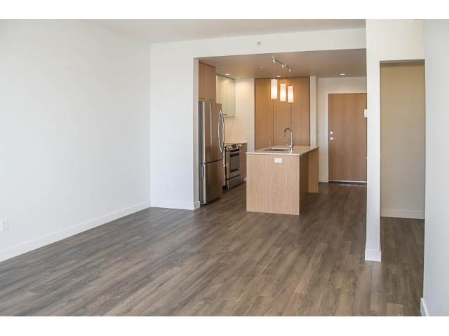 Bright kitchen with light wood cabinets, stainless steel appliances, and hardwood floors. - 501 - 221 East 3rd Street, North Vancouver