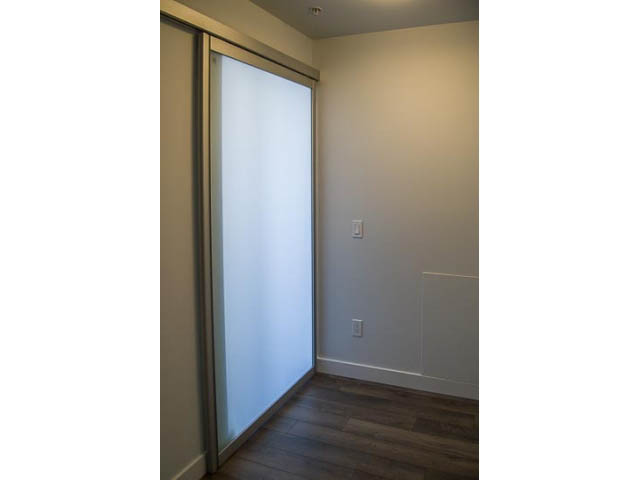 Den with sliding glass door, hardwood floors, and neutral walls. - 501 - 221 East 3rd Street, North Vancouver