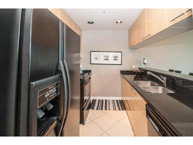 Bright kitchen with black countertops and stainless steel appliances, modern design. - 3602 - 1111 W Pender, Vancouver Downtown