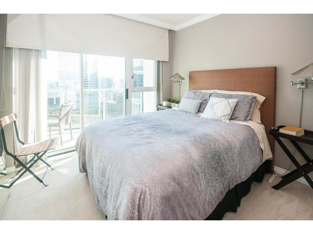 Furnished 1-bedroom condo with a cozy bed, city view, and modern decor. - 3602 - 1111 W Pender, Vancouver Downtown