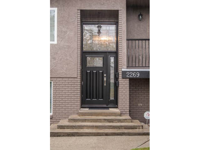 Furnished entrance with brick facade and black door, steps leading up. - 2269 East 40th Ave, Vancouver East Side