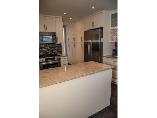 Bright kitchen with granite countertops and white cabinetry. - 2269 East 40th Ave, Vancouver East Side