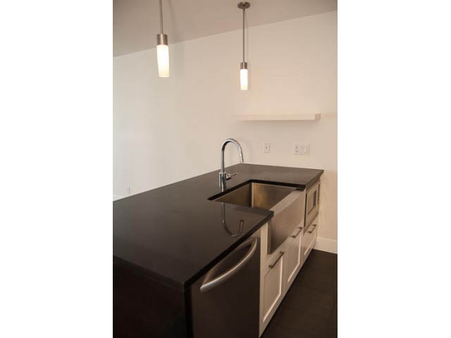 Bright kitchen with dark countertops and modern pendant lights. - 2306 - 888 Homer Street, Vancouver Downtown
