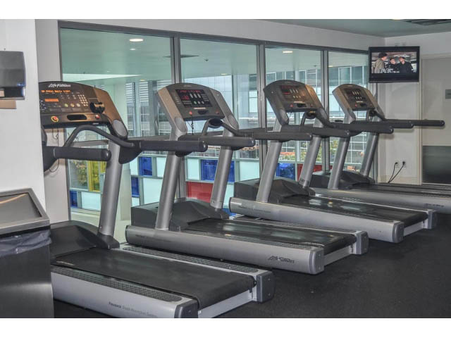 Bright gym with treadmills and city view. - 138 Dunsmuir Street, Vancouver Downtown