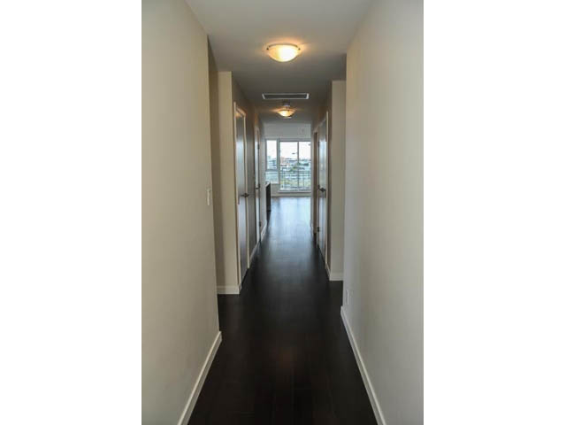 Spacious hallway with dark hardwood floors and city view at the end. - 900 - 9 Smithe Mews, Vancouver Downtown