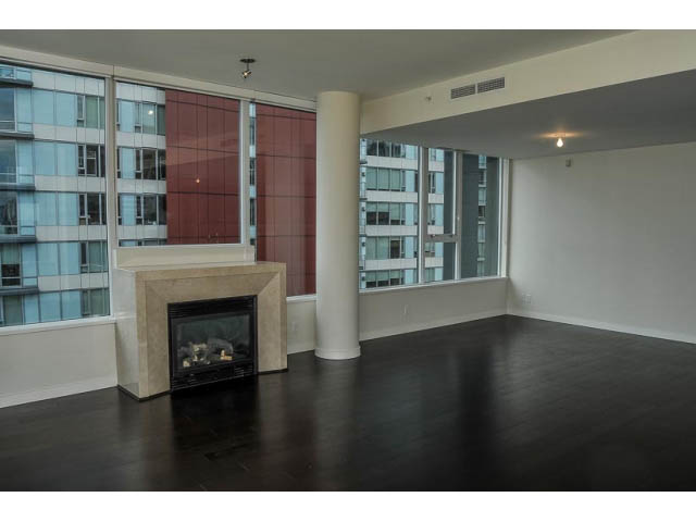 Open-concept living room with hardwood floors, city view, and modern fireplace. - 900 - 9 Smithe Mews, Vancouver Downtown