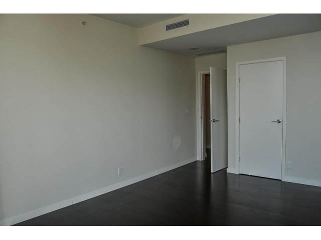 Bright living room with dark hardwood floors and white walls. - 900 - 9 Smithe Mews, Vancouver Downtown