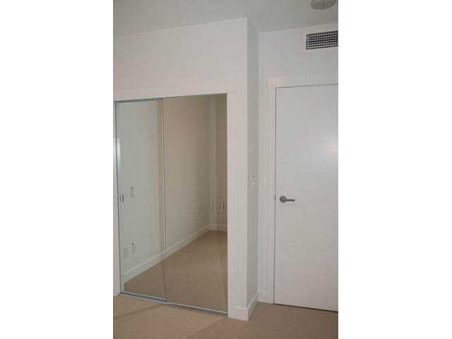 Spacious bedroom with sliding glass doors leading to a balcony. - 906 - 110 Switchmen St, Vancouver East Side
