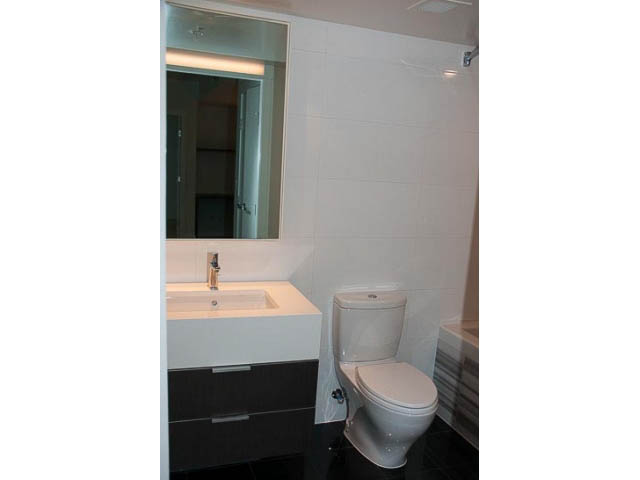 Bright bathroom with modern sink, toilet, and large mirror. - 906 - 110 Switchmen St, Vancouver East Side