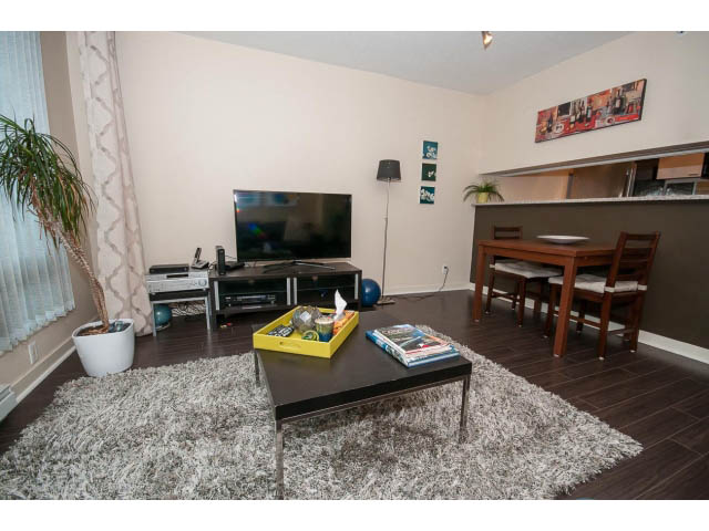 Bright living room with hardwood floors and a large TV, modern decor. - 507 - 1200 West Georgia Street, Vancouver Downtown