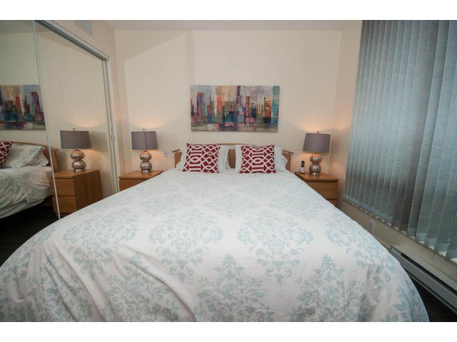 Furnished 1-bedroom with modern decor, cityscape painting, and light blue damask bedding. - 507 - 1200 West Georgia Street, Vancouver Downtown