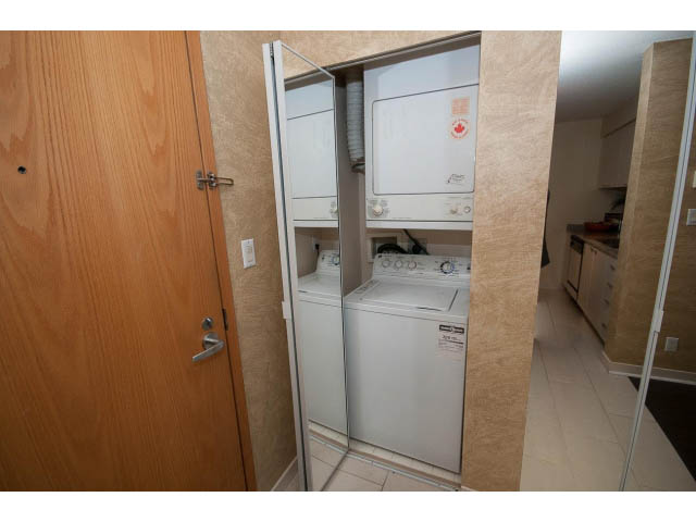Bright laundry room with white appliances and wooden door. - 507 - 1200 West Georgia Street, Vancouver Downtown