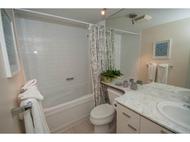 Bright bathroom with marble countertop and white subway tile walls. - 507 - 1200 West Georgia Street, Vancouver Downtown