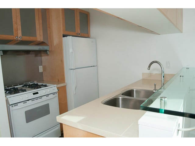 Bright kitchen with white appliances, granite countertops, and wooden cabinets. - 1406 - 1003 Burnaby Street, Vancouver Downtown